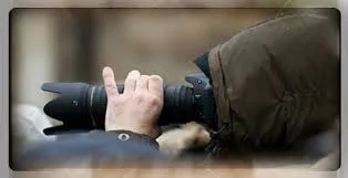 Private investigator conducting concealed surveillance through a long camera lens